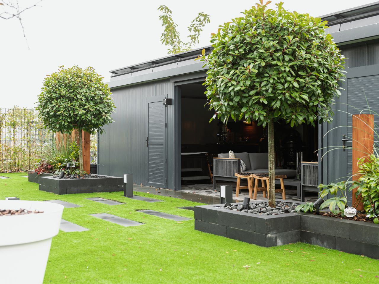 Tuinkamer met berging in sfeervolle tuin in Almere. Isoblox maatwerk en onderhoudsarm.